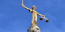 A gold statue of Lady Liberty sits atop the Old Bailey building in London. The Old Bailey is the Central Criminal Court of England and Wales.