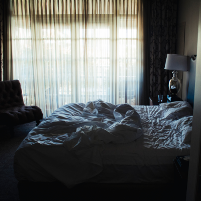 A bedroom with an unmade bed.