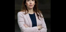 Emily Hunt, activist and Ministry of Justice adviser, stands with her arms crossed, looking face on at the camera, looking stern.