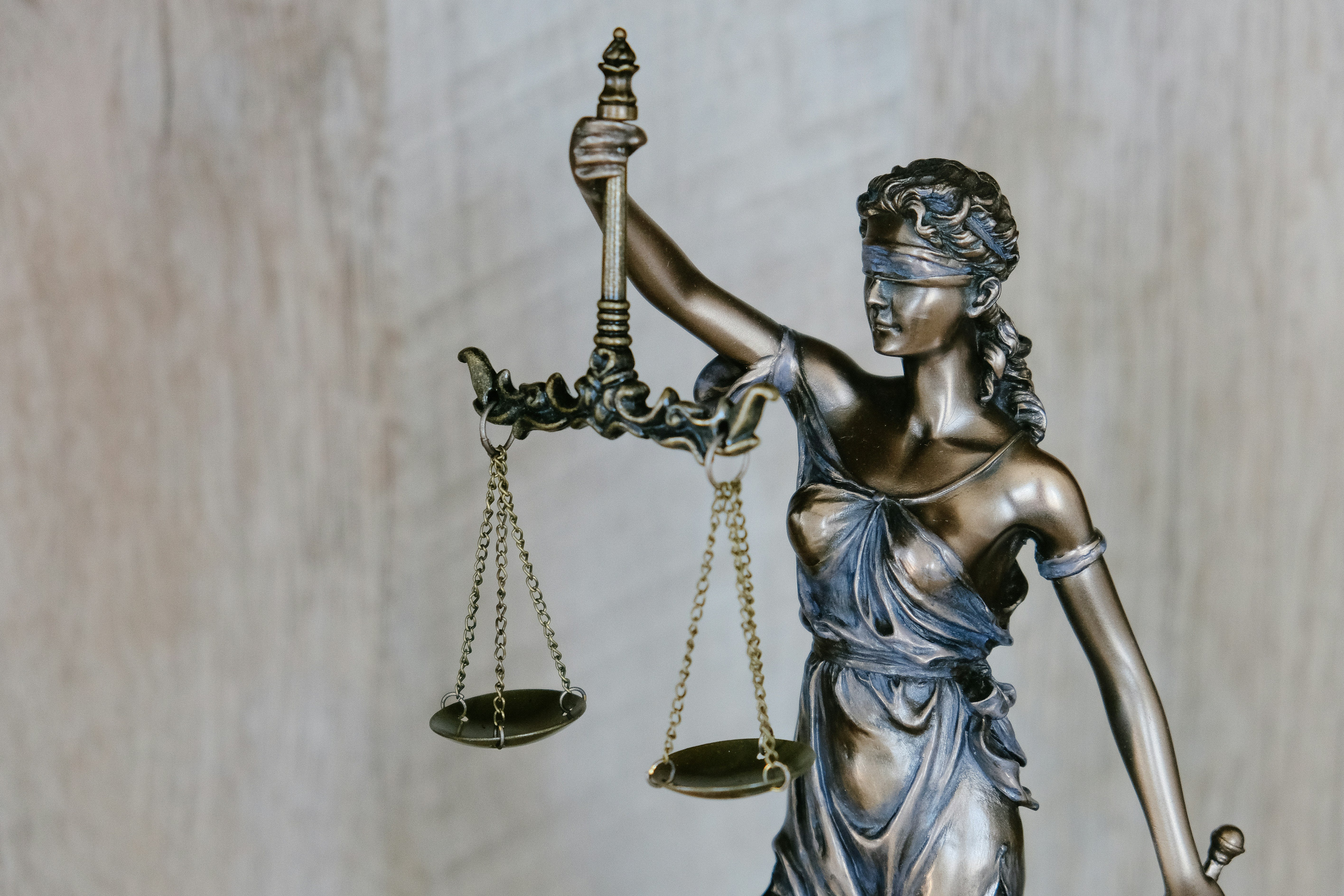 A small bronze statue of Lady Justice holding up scales