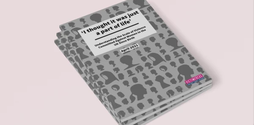 On a table rests three reports piled on top of each other. The front cover of the report is an illustration of a variety of different women's side profiles as silhouettes.