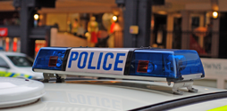 The top of a police car, the focus of the image is on the switched off siren that has 'police' written across it.