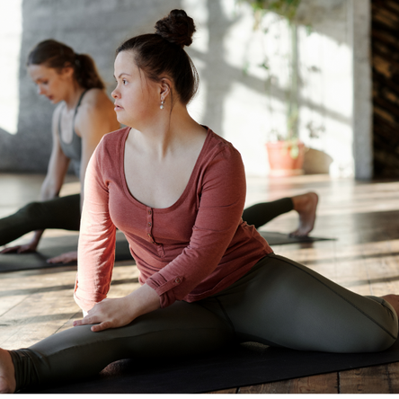 A young woman stretches her legs out in a yoga pose.